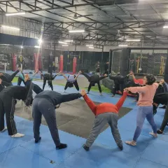 Recovery and mobility are just as important as the workout itself. Here, our tribe participates in a group stretching session, fostering community while taking care of their bodies.