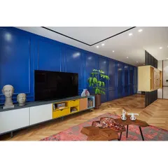 Color can tell a story. For this Bengaluru apartment, a captivating Parisian blue paneled wall becomes the centerpiece, camouflaging doors and creating a sense of intrigue and personality, showcasing our ability to craft eclectic and vibrant interiors.