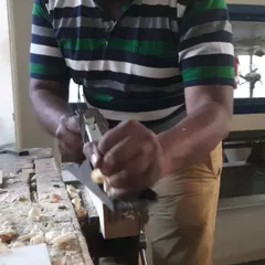 A student uses a hand plane to smooth a wood surface. This traditional technique provides a level of finish and control that power tools often cannot match.
