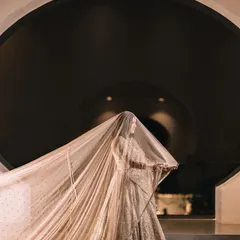 A dramatic and artistic shot of the bride, her long, flowing veil creating a powerful silhouette against a circular architectural feature.