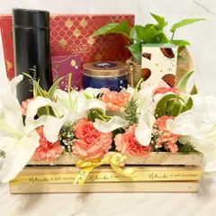 Gifting luxury is easy with us. This wooden crate hamper is overflowing with fresh lilies and carnations, alongside premium chocolates, a flask, and a live plant for a truly impressive gift.