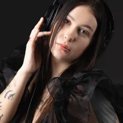 Another portrait of the DJ against a black background, creating a low-key, intimate feel that focuses on her connection with the music.