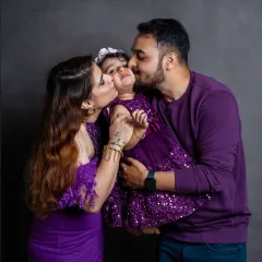 Showered in kisses, this little girl is the center of her parents' world. Our studio sessions are perfect for capturing these intimate and loving family interactions.