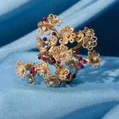 The cherry blossom ring, a testament to nature's artistry. Handcrafted in 18k gold, this statement ring is adorned with tiny, perfectly spherical, no-heat Mozambique rubies that resemble luscious cherries.