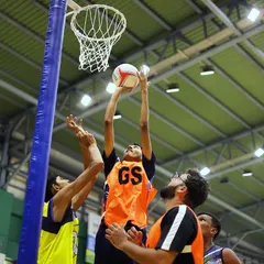 This is the suspense of competition in a single frame. A Goal Shooter (GS) extends for the basket while defenders leap to block during the National Games Netball Championship. It’s these split-second moments that tell the story of a match.