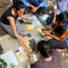 The team gathers on the floor to explore different combinations of tiles, wood veneers, and laminates. This tactile approach is a fun and essential part of our creative process.