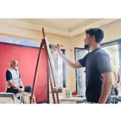 Setting up the canvas and palette for a portrait demonstration at the Raja Ravi Varma Art Gallery for students. The focus is on showing how to capture a likeness and mood quickly and effectively.