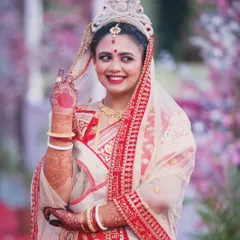 A candid, smiling portrait of a bride during her Bengali wedding ceremony, capturing her natural joy.