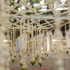 A close-up view from under a floral chadar, showing the intricate jasmine weave.