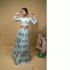 This baby blue floral printed lehenga set offers a fresh and modern aesthetic. The long-sleeved crop top and tiered skirt are perfect for a daytime event or a destination wedding.