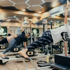 The side plank is a powerful move for targeting the obliques and improving lateral stability. Here, a group class works in unison, showcasing the strength and focus that Pilates cultivates.