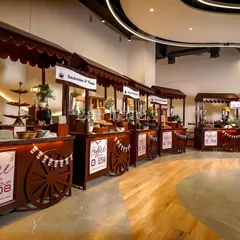 We transformed a corporate space into a bustling "Coffee Fest" with a series of custom-designed stalls. This wide shot shows the scale of the event, creating a market-like atmosphere that encourages guests to explore, connect, and enjoy the experience we built.