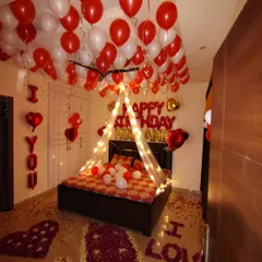 This is one of my most requested romantic birthday surprises for a husband or partner. The setup includes a fairy light canopy over the bed, red and white balloons, and 'I LOVE YOU' spelled out with rose petals on the floor.