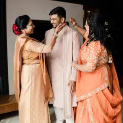 A tale of a groom who believed in a timeless wardrobe. Here, he is getting ready with his mother and another family member, his blush pink sherwani a picture of understated elegance.