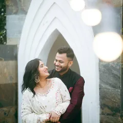 A happy, candid embrace in front of one of our unique white architectural backdrops. The string lights add a touch of warmth and magic to this pre-wedding portrait.