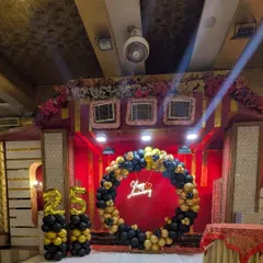 For a 25th anniversary, I created this elegant stage decoration. The setup includes a circular balloon arch in black and gold, a "Happy Anniversary" neon sign, and large foil number balloons, creating a perfect focal point for the celebration.