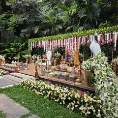 An angled view of the outdoor garden setup, showing the floral peacock prop and the path leading to the stage.