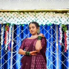 A beautiful portrait of a client with the decor in the background. The blue curtain with a crisscross light pattern and floral border creates a stunning photo opportunity.