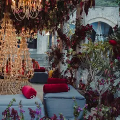 The lounge seating area for a traditional ceremony, surrounded by our elaborate floral decor. This shot captures the calm before the guests arrive, showing the intricate details like the custom candle stands and lush floor arrangements.