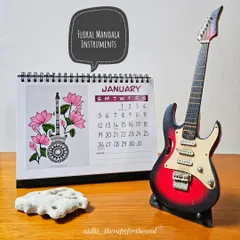 The January page, featuring a mandala-patterned guitar surrounded by lotus flowers. I've styled it here with a miniature guitar to show the inspiration.