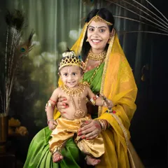 The divine bond between Yashoda and her little Krishna. This mother-son portrait captures a moment of pure love and affection, beautifully styled with traditional clothing.