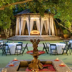 The Colonial Bandstand set for an evening reception, with its antique pillars and surrounding lawns creating an atmosphere of timeless grandeur.