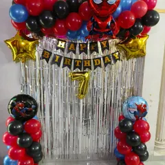 A superhero celebration with this action-packed Spiderman theme for a 7th birthday. It features red, black, and blue balloons, a silver fringe curtain, and multiple Spiderman foil balloons.