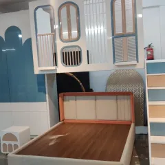 A close-up of the whimsical loft bed, featuring a unique façade with assorted window shapes. This piece is crafted to be a magical space where functionality and playful design meet.