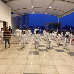 Students at the Prestige Falcon City dojo warm up with basic movements, preparing their bodies and minds for the focused training ahead.
