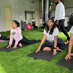 Our members finding their focus during a yoga session. The green turf provides a comfortable and calming environment for floor exercises and mind-body connection.