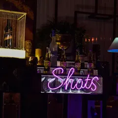 A dedicated 'Shots' station with a neon sign. This is where the fun is, with a full setup for Jello shots, Jager bombs, and other party starters.