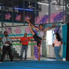A gymnast strikes a pose of incredible flexibility and balance during a performance. Our showcases are a fantastic opportunity for students to demonstrate their skills.