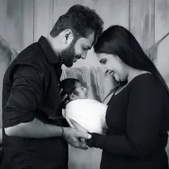 A classic black and white family portrait showing parents lovingly gazing at their newborn. This style creates a timeless and elegant memory of your family's beginning.