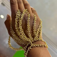 A close-up of our bestselling pearl hand harness. I designed this piece to be delicate yet make a statement, with cascading strands of tiny pearls that beautifully adorn your hand for any festive occasion.