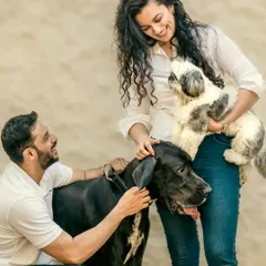I love capturing the story as it unfolds. Here, a man crouches to pet his Great Dane while his partner holds their Shih Tzu, a candid moment of affection during our outdoor pet photography session.
