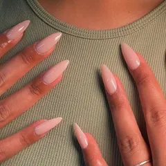 A perfect set of long, stiletto-shaped nails in a simple, elegant nude. This look elongates the fingers and provides a clean canvas that works for any occasion. It’s all about the perfect shape and flawless application.