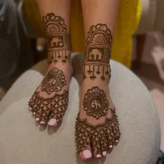 A lovely elephant-themed mehandi for the feet. The design includes elephant motifs in the center and on the ankle band, with delicate hanging details.