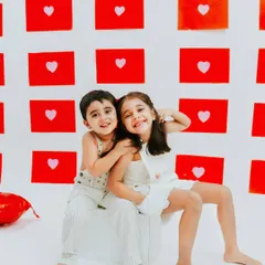 Two siblings smiling brightly for the camera. Their coordinated outfits and happy expressions make for an adorable and heartwarming photo.