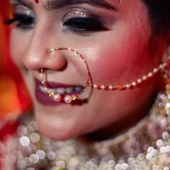 A detailed close-up of a bride's face, highlighting her beautiful pearl-adorned nath (nose ring) and sparkling eye makeup. I focus on these small details to create stunning and intimate bridal portraits.