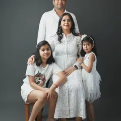 A stylish family portrait in our studio. We work with families of all sizes to create elegant and coordinated group photos against a simple, modern backdrop.