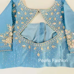 A simple and elegant keyhole back design on a light blue blouse. The leaf-pattern embroidery is done with subtle gold thread and sequins.