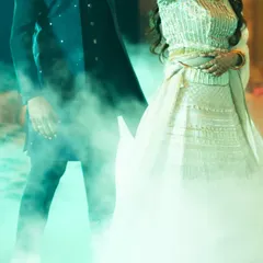 A dreamy, cinematic shot of the couple during their Sangeet performance, surrounded by smoke. This frame captures the magic and romance of their first dance as a soon-to-be-married couple.