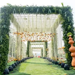 For this traditional wedding, I designed a grand entrance tunnel framed with lush greenery and adorned with hanging floral strings and marigolds. The terracotta urns add an earthy, rustic touch to the magnificent structure.