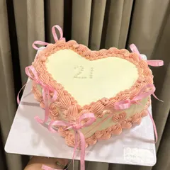 For the love of vintage charm. This heart-shaped cake features intricate Lambeth piping and delicate ribbon bows, perfect for celebrating a 21st birthday with a touch of classic elegance.