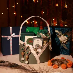 A complete look at one of the corporate Diwali gift sets for Yatra, featuring a hamper basket, a fabric-wrapped gift box, and a smaller branded box, all set against a festive backdrop.
