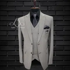 A sleek and sophisticated light grey three-piece suit. Paired with a black shirt and patterned tie, this look is perfect for the modern gentleman in a business or formal setting. Grey is a color that never goes wrong.