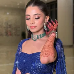 Another angle showcasing the beautiful henna and the contrast between the bold blue outfit and the soft, glamorous makeup.
