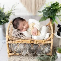 A classic newborn pose on a beautiful boho-style bed, complete with a tiny teddy bear for company. My focus is always on safe and comfortable posing for your baby.