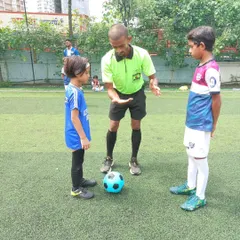 A referee gives instructions to our young U-7 captain before a match. These moments are important learning experiences for our future leaders.