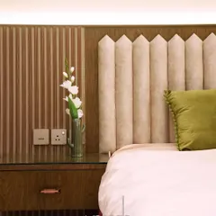 In this parent's bedroom, we used a mix of textures to create visual accents and warmth. The design features a custom upholstered headboard alongside fluted wooden paneling, creating a serene and sophisticated retreat.